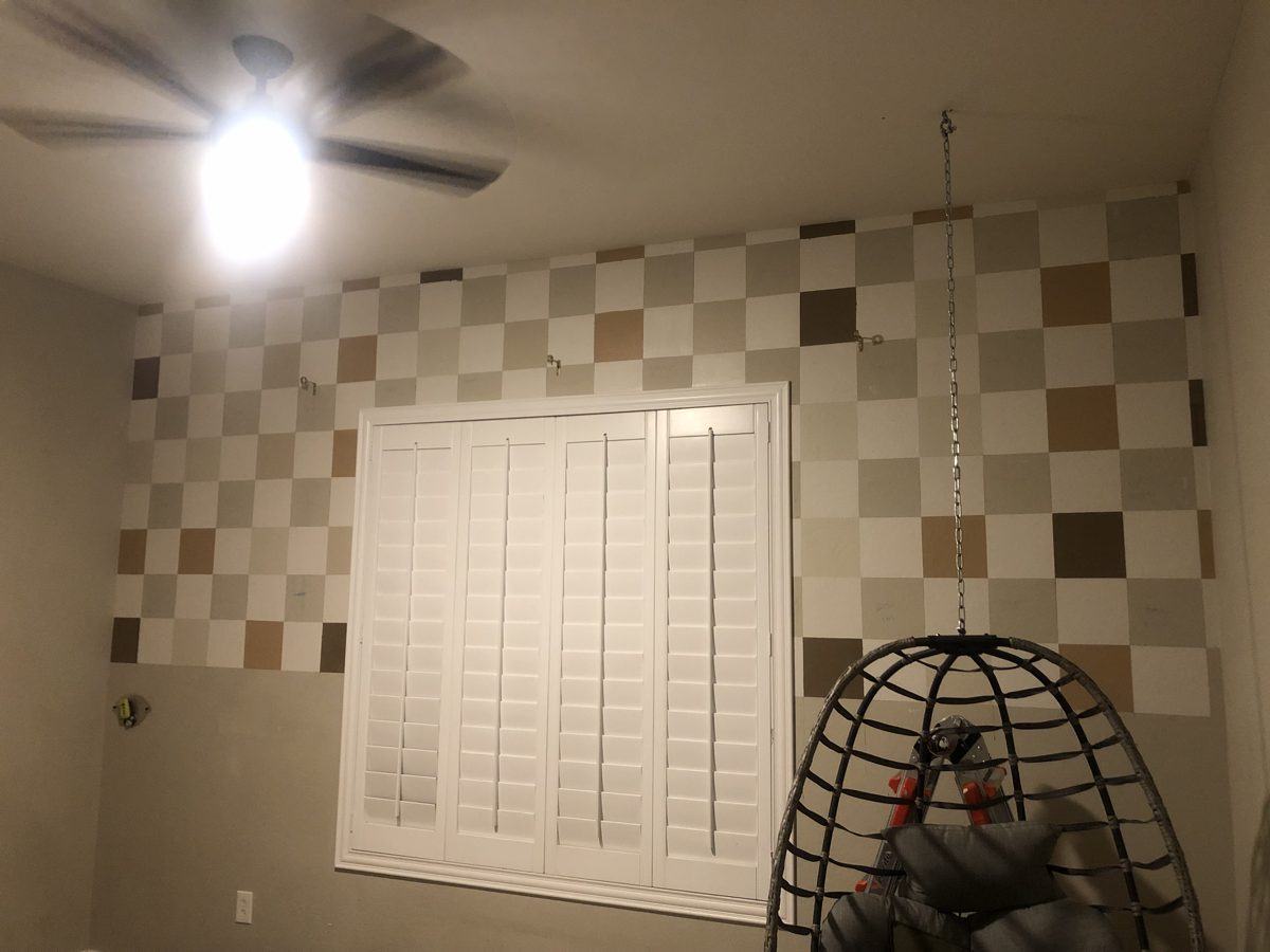 Checkered wall in progress, painted squares on a playroom wall